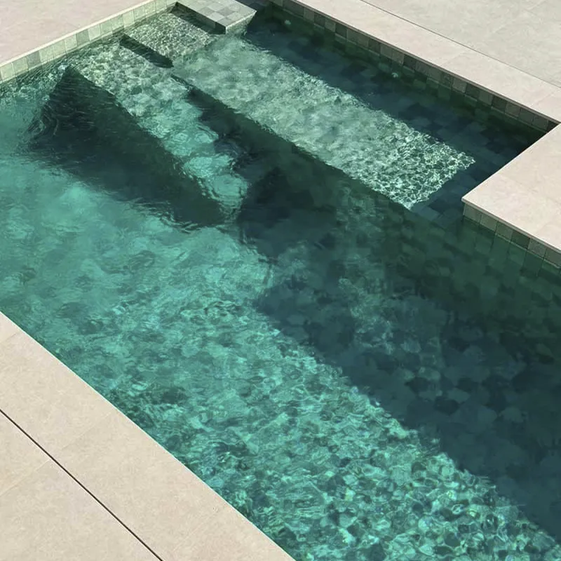 Diseño exterior con estilo natural realzado por una piscina con azulejos verdes