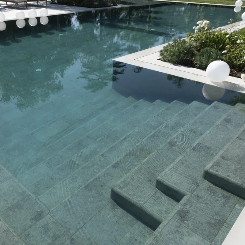Piscina con azulejos verdes utilizada como recurso decorativo para un entorno relajante