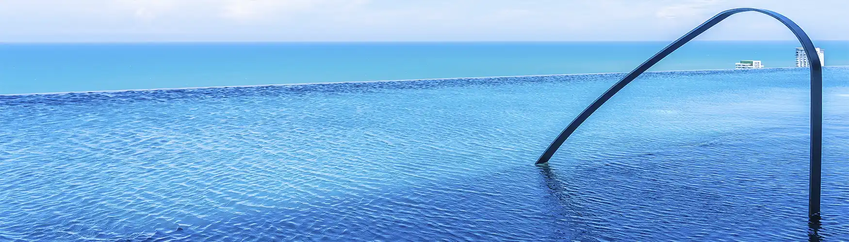 Piscina infinita de azulejos azules con una impresionante caída al mar