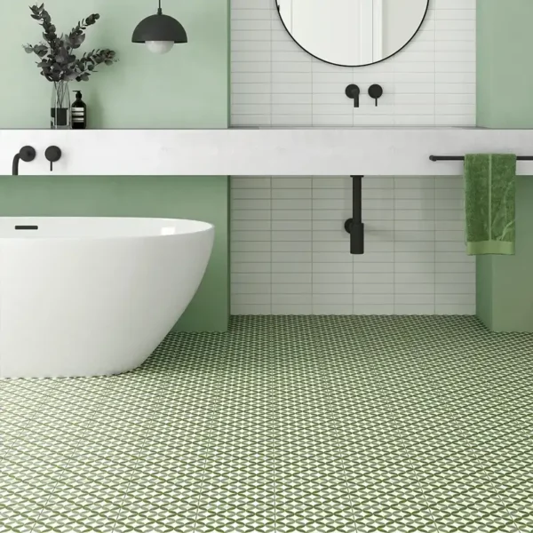 Bañera colocada en un entorno con azulejo en gama verde y buena luz