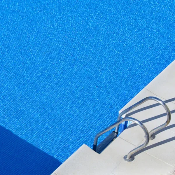 Revestimiento continuo logrado con azulejos imitación gresite para piscinas en tonos azules