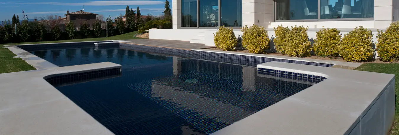 Piscina revestida con gresite negro que aporta profundidad visual y estilo sofisticado
