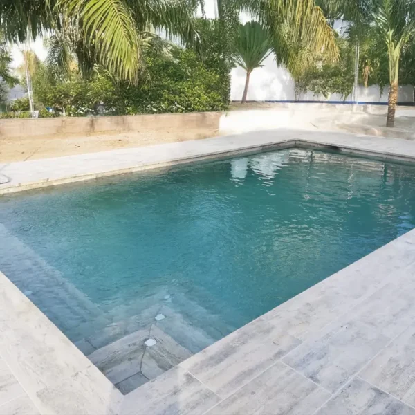 Imagen con diseño cálido protagonizada por una piscina con porcelánico madera en todo el entorno