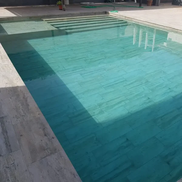 Composición uniforme donde destaca el porcelánico imitación madera en la piscina